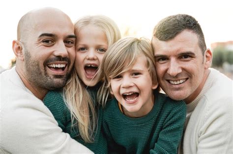 Familia lgbt al aire libre feliz pareja de hombres gay e hijos divirtiéndose juntos en el parque