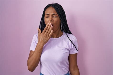 Mujer Afroamericana Con Trenzas De Pie Sobre Fondo Rosado Aburrida