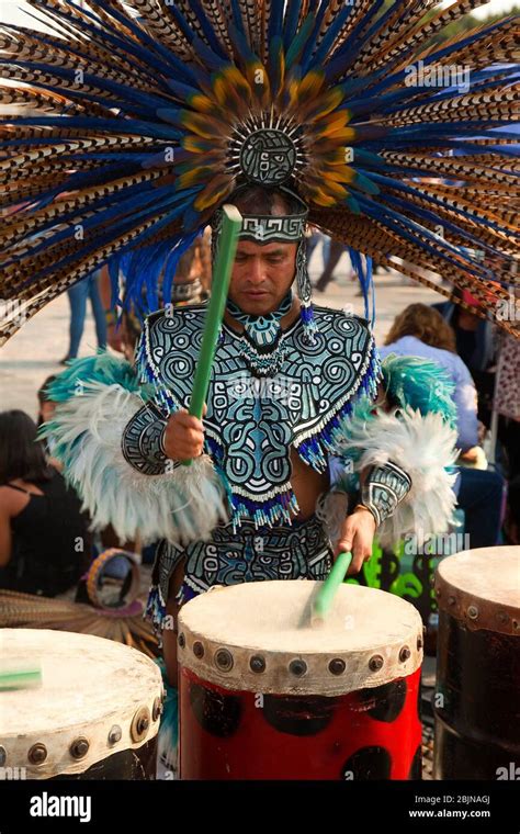 Indigenous Dancer Playing Drums In Traditional Costumes During The