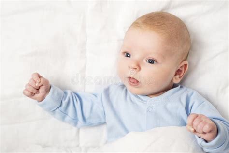 Portrait Of A Cute Baby Lying Down On A Bed Baby On White Cloth Lying