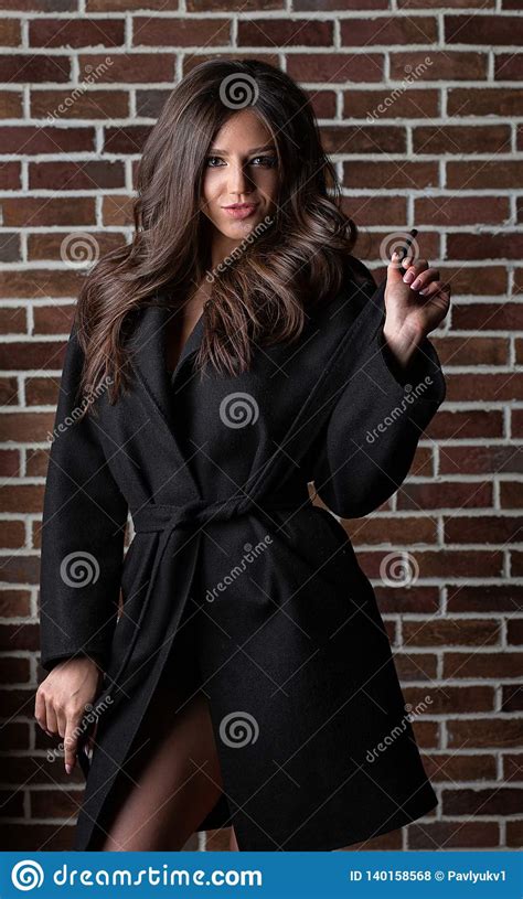 Elegant Brunette Girl With Long Curly Hair Wearing Coat Posing Near