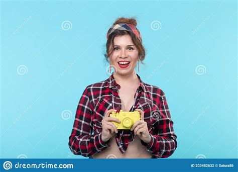 Portrait Of A Pretty Young Positive Woman In A Plaid Shirt Holding A