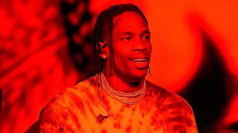 Travis Scott In Red Background Wearing Gold Chains On Neck And Studs