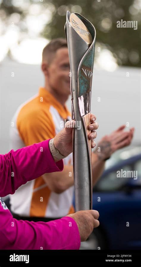 A Baton Bearer Holds The Queens Baton During A Visit From The