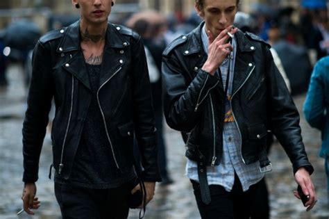 Smoking Man Wearing A Black Leather Biker Jacket Over A Pale Blue Checkered Shirt And Black