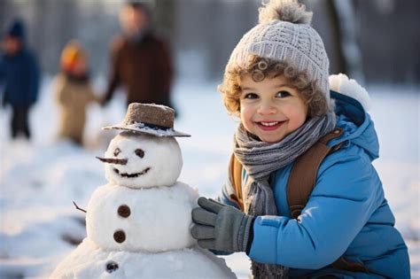 Un niño pequeño está construyendo un muñeco de nieve en la nieve imagen