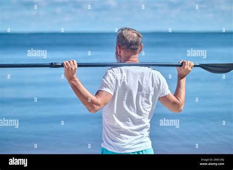 Harmony Back View Of Man Holding Oar On His Shoulders Standing Looking