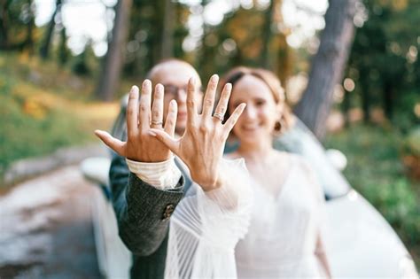 Premium Photo Bride And Groom Show Their Wedding Rings On Outstretched Arms While Standing By