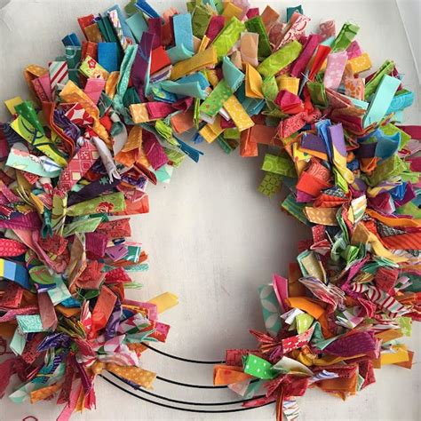 A Wreath Made Out Of Different Colored Pieces Of Paper On Top Of A White Table