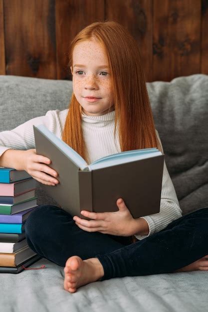 Une Fille Aux Cheveux Roux Avec Un Livre Dans Les Mains Est Assise Dans