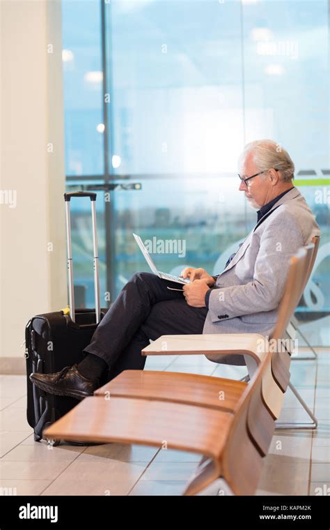 Senior Businessman Using Laptop At Airport Terminal Stock Photo Alamy