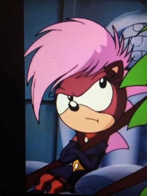 A Cartoon Character With Pink Hair And Green Leaves In Front Of A Tv