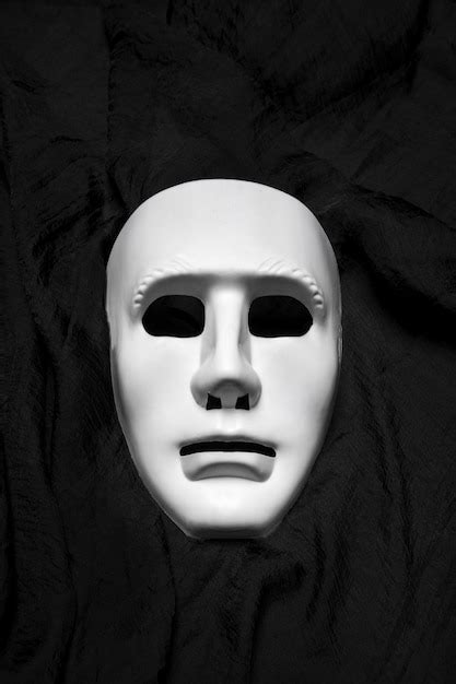 Premium Photo Expressionless White Masks On A Black Cloth