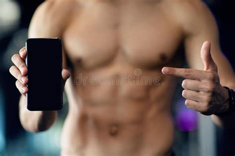 Workout App Muscular Man With Naked Torso Pointing At Blank Smartphone