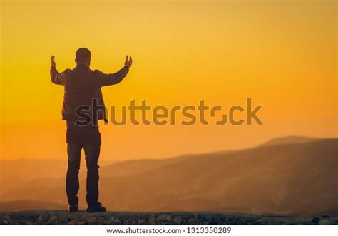 Silhouette Man Hands Raised Sunset Mountains Stock Photo