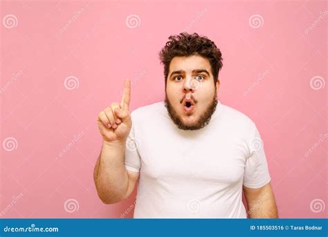 Portrait Of Surprised Fat Man In White T Shirt And With Beard On Pink