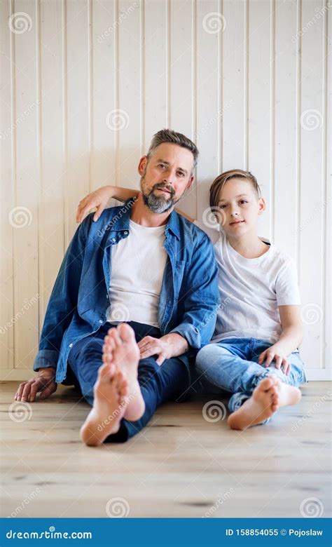 Mature Father With Small Son Sitting Indoors Looking At Camera Stock Image Image Of Inside