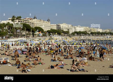 Tourists Sunbathing On Beach Cannes Beach French Riviera Stock Photo