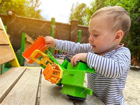 Um Menino Bonitinho De Um Ano E Meio Brinca Com Carro De Brinquedo No