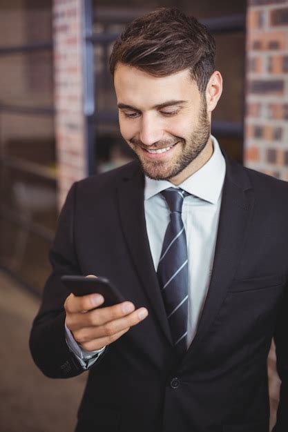 Premium Photo Happy Businessman Using Cellphone In Office