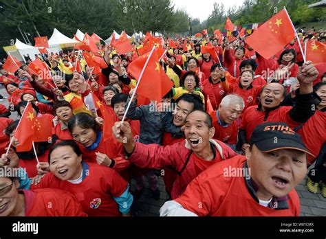 People Wave Chinese National Flags During A Parade To Celebrate The