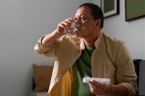 Retrato De Um Homem Mais Velho Tomando Seus Comprimidos Em Casa Foto