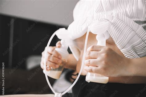 Mom using breast pump machine to pumping milk for her son in bedroom. Colostrum milk ...