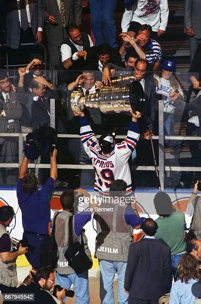 Nick Kypreos of the New York Rangers holds up the Stanley Cup Trophy ...