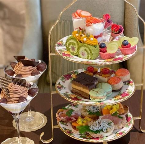 Three Tiered Trays Filled With Different Types Of Desserts And Pastries