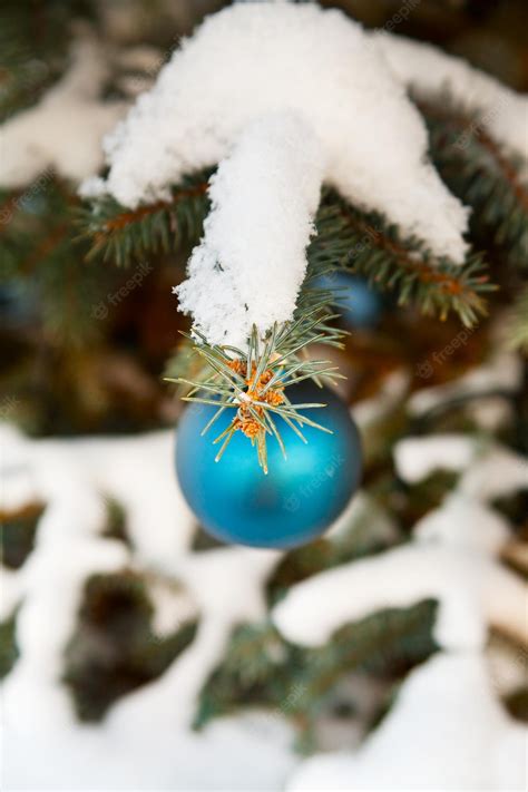 Premium Photo | Christmastree decorations on tree under snow outdoor