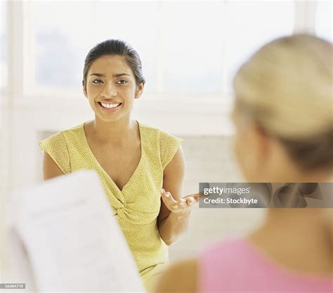 Two Young Women Talking To Each Other In An Office High Res Stock Photo