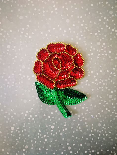 A Red Rose Brooch With Green Leaves