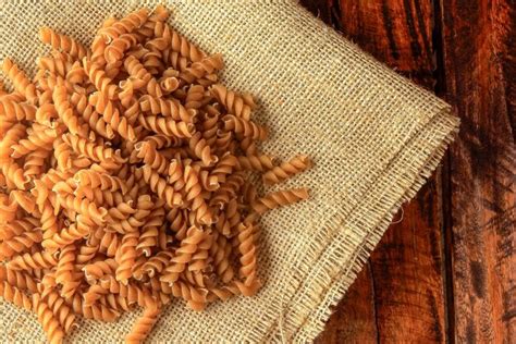 Premium Photo Raw Whole Grain Fusilli Pasta On Rustic Fabric Over