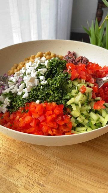 A White Bowl Filled With Chopped Vegetables On Top Of A Wooden Table