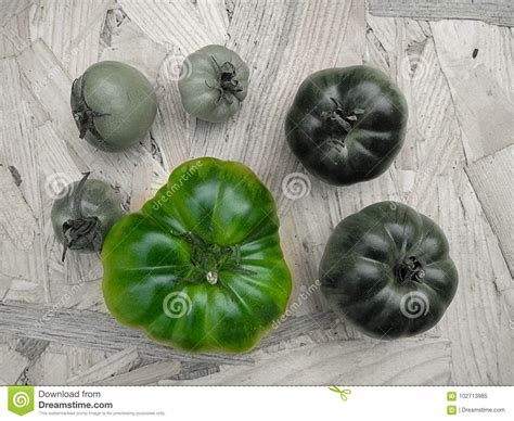 Los Tomates En Una Tabla En Cambio Colorean El Verde Blanco Y Negro