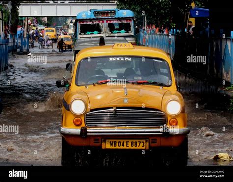 Commuters Wade Through A Waterlogged Street In Floodwaters Following