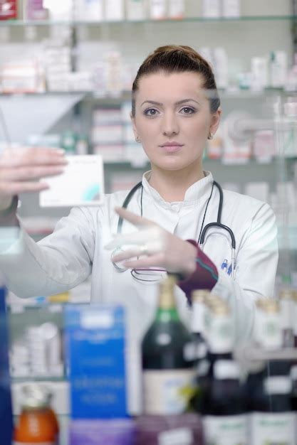 Feliz mujer farmacéutica alegre farmacéutica de pie en la farmacia