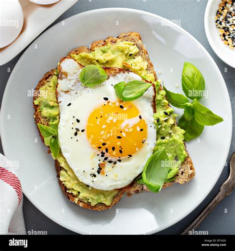 Avocado Toast With Fried Sunny Side Up Egg Overhead View Stock Photo