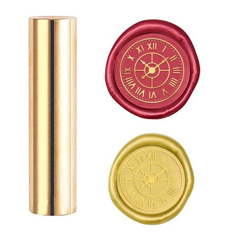 A Gold And Red Clock Stamp Next To A Metal Tube With A Wax Seal On It