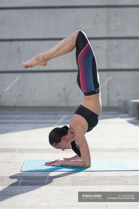 Woman hand-standing in yoga positio — sport, sports wear - Stock Photo | #160559052