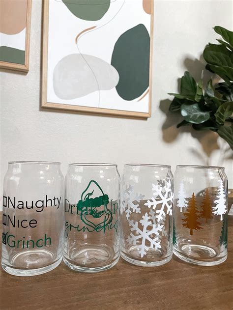 Four Glasses Sitting On Top Of A Wooden Table Next To A Potted Green Plant