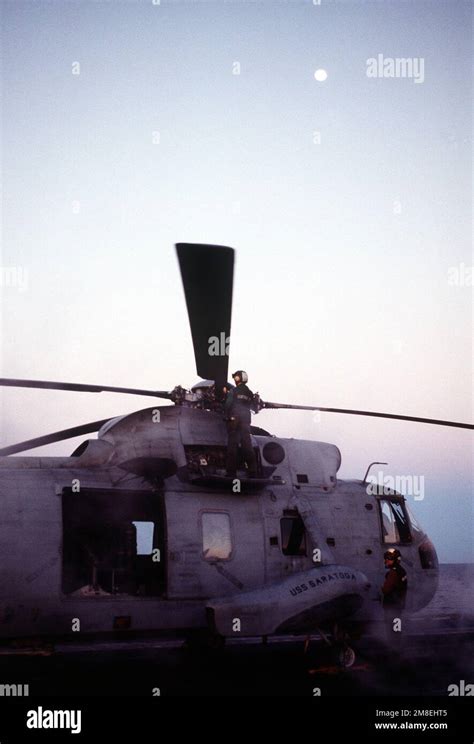 A Maintenance Crewman Checks A Main Rotor Blade On A Helicopter Anti