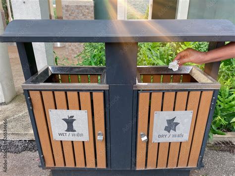 Asian old woman throwing tissues into the trash bin, Recycling bin, Sort and dispose of items in ...