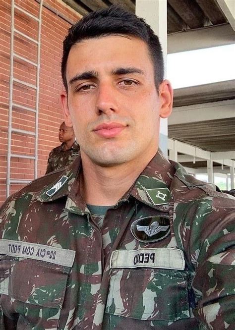 A Man In Uniform Standing Next To A Brick Building