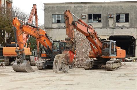 Three Heavy Wheeled Front Loaders Or Bulldozers On A White Isolated