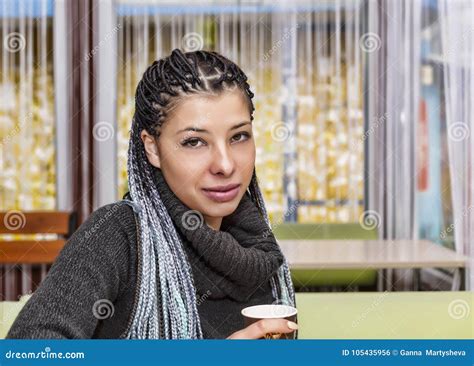 A Young Hispanic Happy Girl Is Sitting At A Table In A Cafe Stock