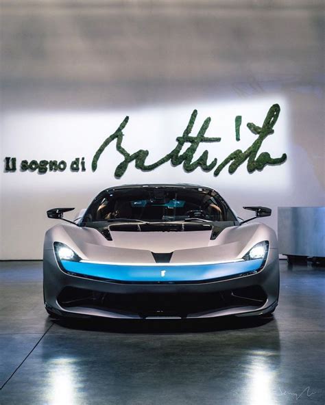 A Silver And Blue Sports Car Parked In Front Of A Sign