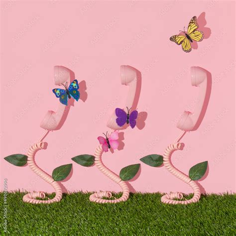 Spring creative layout with pink retro phone handset with colorful butterflies, leaves on pastel ...