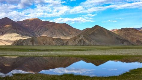 The Calm And Beautiful Lake At The Foot Of The Mountain Reflects The