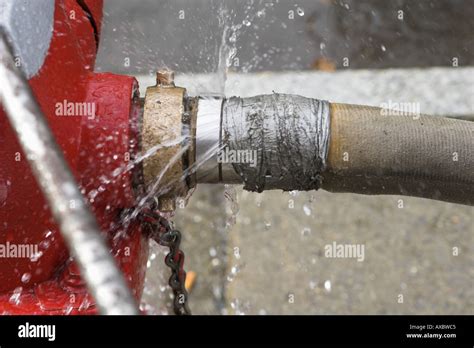 Leaking Red Fire Hydrant And Fire Hose Attached Stock Photo 5483972